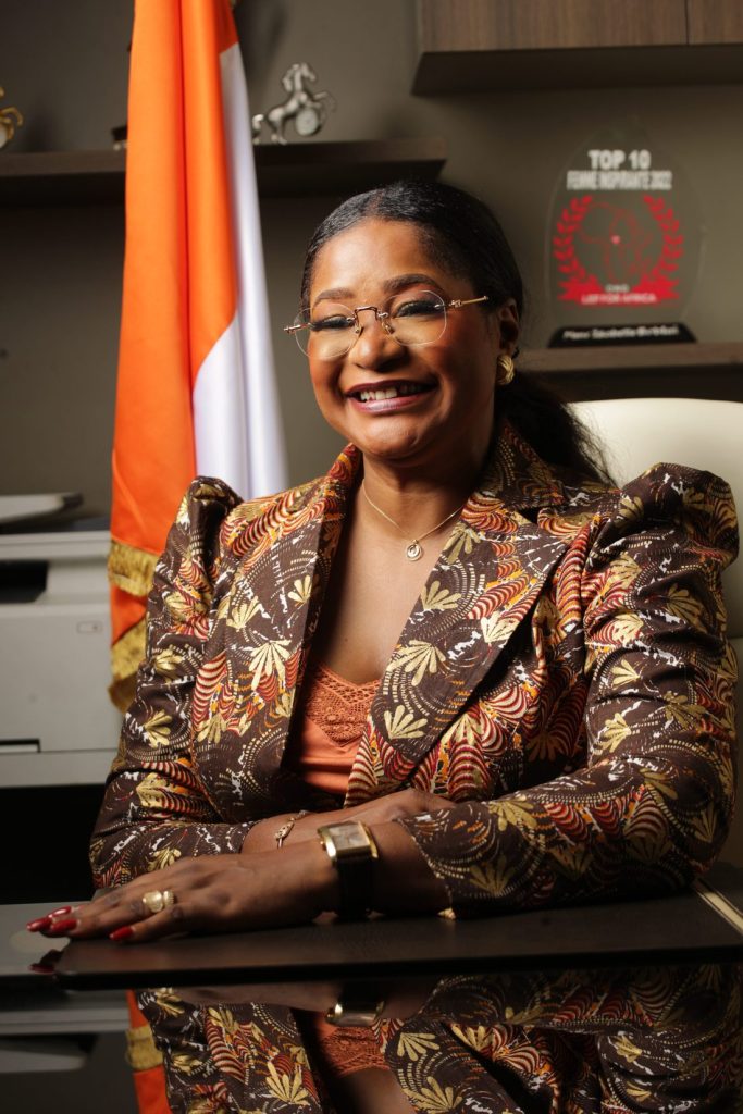 Madame Isabelle Boblaï Douassoh souriante à son bureau, en tenue de pagne