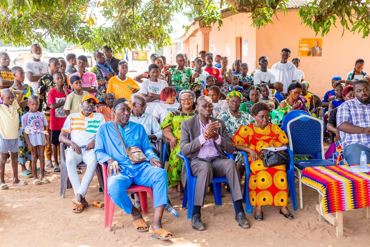 Notables, femmes et jeunes assis côte à côte lors d'une rencontre